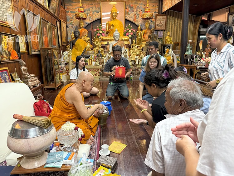  寺廟內龍婆瑪哈蘇拉薩 正在送一些聖物給善信, 其中一位某國人想要多一支被拒絕